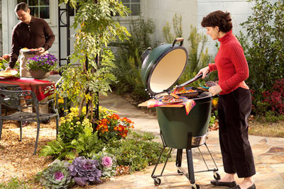 lady cooking on a big green egg grill